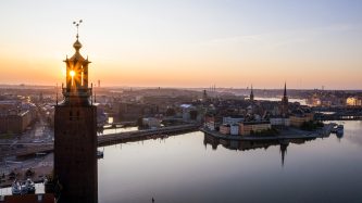 Kvällsskymning med vy över Stockholms stadshus och vattnet.