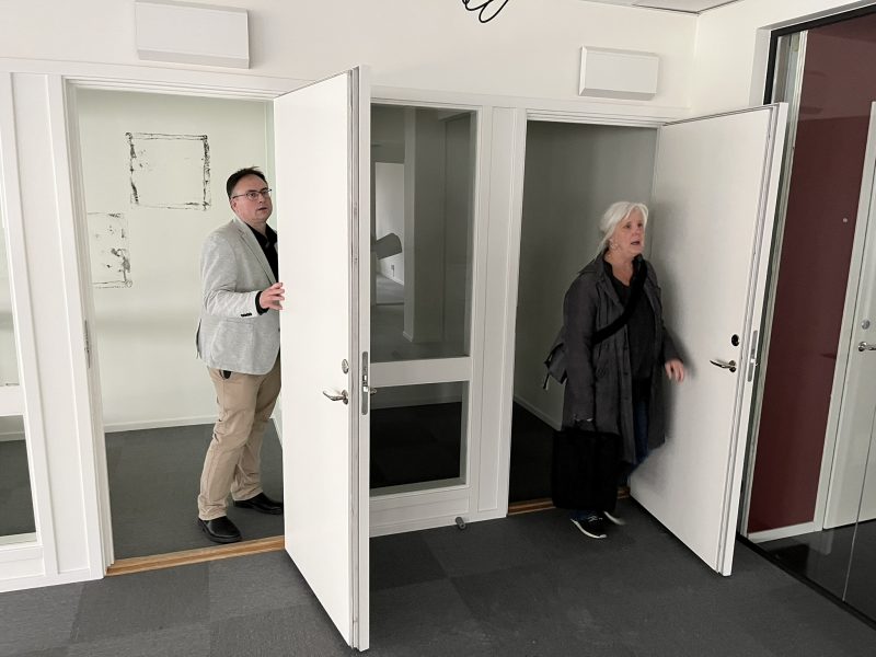 Två personer inventerar dörrar och fönster inför återbruk i kontorsmiljö.