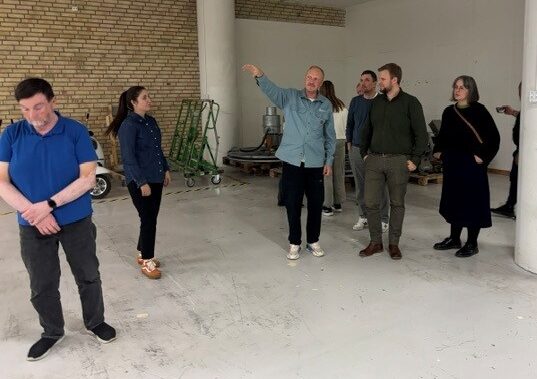 En grupp människor står i en lagermiljö